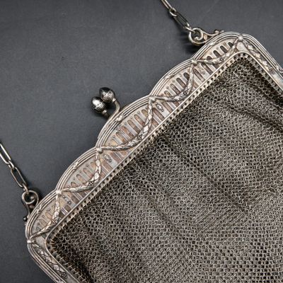 an antique silver metal mesh purse with a chain strap and clasp