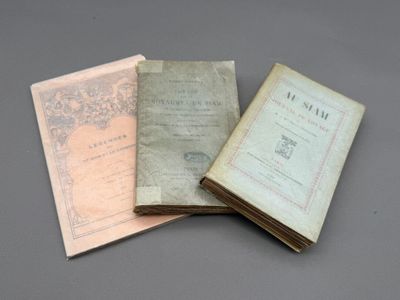 trois vieux livres posés l'un sur l'autre sur une table