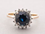 a close up of a blue sapphire and diamond ring