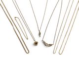 un ensemble de colliers et de boucles d'oreilles posés sur une surface blanche