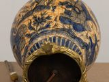 a blue and gold vase sitting on top of a table