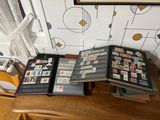 a lot of stamps on a desk next to a phone