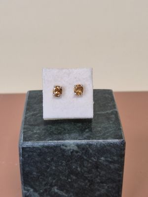 un gros plan sur une paire de boucles d'oreilles posées sur un bloc de marbre