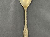 a spoon with a gold handle sitting on top of a table