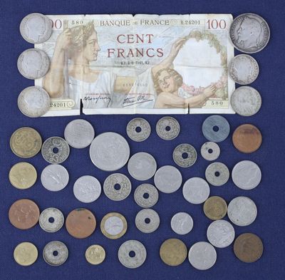 beaucoup de pièces et un billet de banque posés sur une surface bleue
