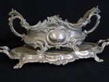 a silver serving dish on a black background