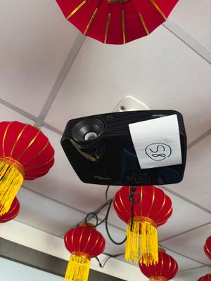 red and yellow lanterns hanging from the ceiling above a projector