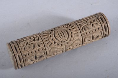 un vieux cylindre sculpté, orné d'un motif sur une surface blanche