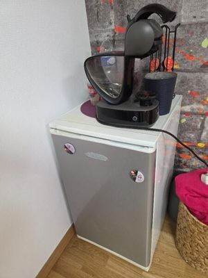 un petit réfrigérateur sur lequel est posée une cafetière