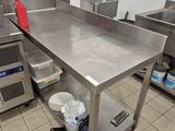 une grande table en acier inoxydable dans une cuisine professionnelle