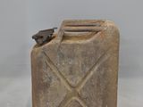 an old jerry can with a metal handle on a white surface