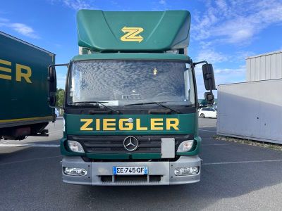 un camion vert garé sur un parking
