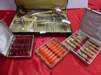de nombreux types de couteaux et de cuillères dans un coffret