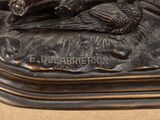 bronze statue of a man laying on a horse with a bird on its back