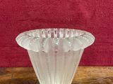 clear glass vase sitting on a wooden table with a red background