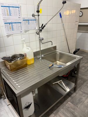 un évier au milieu d'une cuisine, équipé d'un robinet