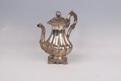 a silver tea pot on a white table
