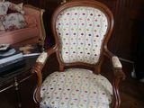 une chaise qui se trouve dans un salon où il y a une horloge accrochée au mur