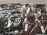 de nombreux sacs de vêtements posés les uns à côté des autres sur une étagère