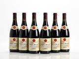 six bouteilles de vin sont alignées sur une surface blanche