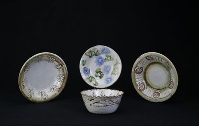 quatre types différents d'assiettes et de bols en porcelaine sur fond noir
