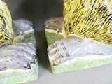 une paire de serre-livres en céramique représentant des animaux, de couleur jaune et noire, posés sur un fond blanc