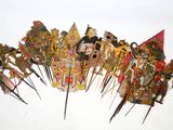 de nombreux types de masques fixés sur des tiges, disposés sur une surface blanche