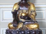 une statue de Bouddha assis sur une boîte rouge