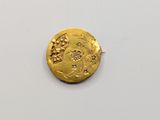 a close up of a gold coin on a white surface