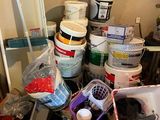 many buckets of paint sitting on the floor in the room
