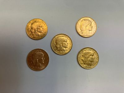 quatre types différents de pièces d'or sur une surface blanche