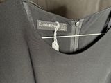 a close up of a black dress hanging on a hanger