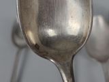 a close up of a silver spoon and two spoons