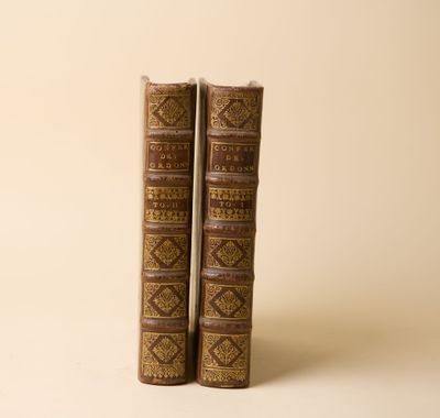 deux vieux livres posés l'un sur l'autre sur une surface blanche