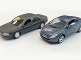 two toy cars sitting next to each other on a white surface