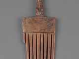 an image of a wooden comb with a man on top of it