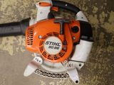 an orange and white blower sitting on top of a dirty floor