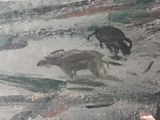 a painting on the wall of a building with animals on it