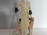 une figurine représentant une femme accompagnée de deux chiens