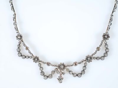 un collier en argent orné d'un bouquet de perles de cristal sur fond blanc