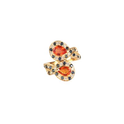 un gros plan d'une bague sertie d'une pierre orange et de saphirs bleus