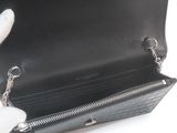 someone is holding a black purse with a chain around it