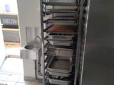 a metal rack with trays of food in a kitchen