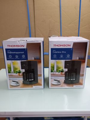 two boxes of coffee on a table with a cup on it