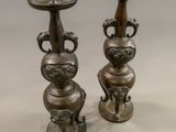 two metal vases that are sitting on a table
