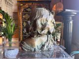 a statue of a woman sitting on top of a clear box