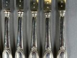 six silverplated knives are lined up next to each other on a table