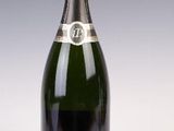 une vieille bouteille de champagne posée sur une table blanche