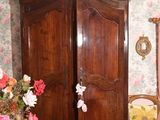 une grande armoire en bois dans une pièce au papier peint à motifs floraux