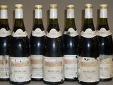 six bouteilles de vin sont alignées sur une table